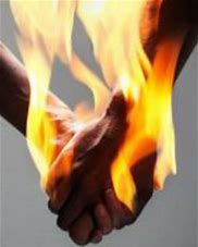 Two people holding hands and their hands are on fire