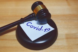 Gavel with sticky note that says covid-19 on it