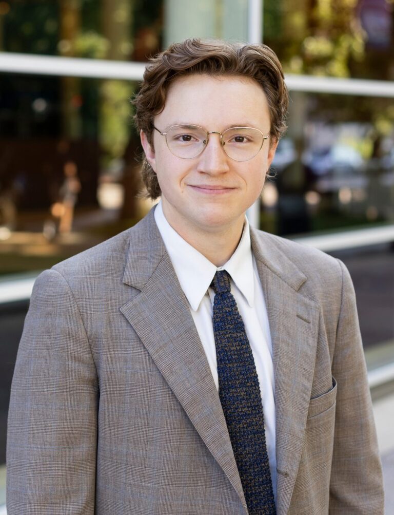 Matthew Hawk, Attorney at KEW standing in front of glass front building